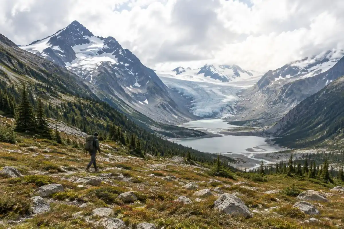 Long torso hiker crossing a stony meadow in a huge valley