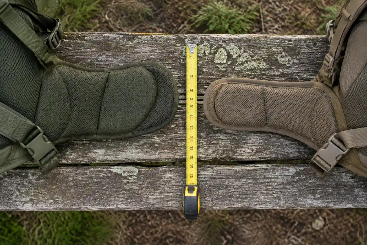 Two different shaped hip belts laid on a bench for comparison