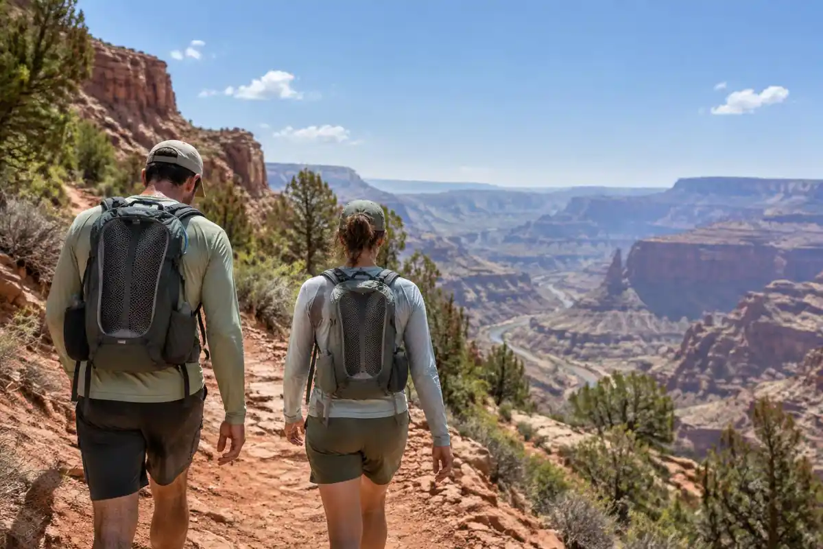 Hikers walking a hot dry canyon trail in sun shirts with ventilated packs