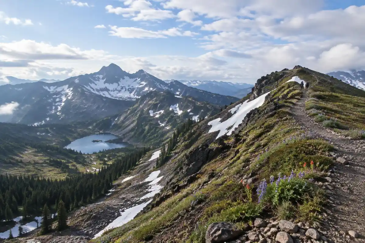 Alpine ridge crest with a narrow trail above a green basin