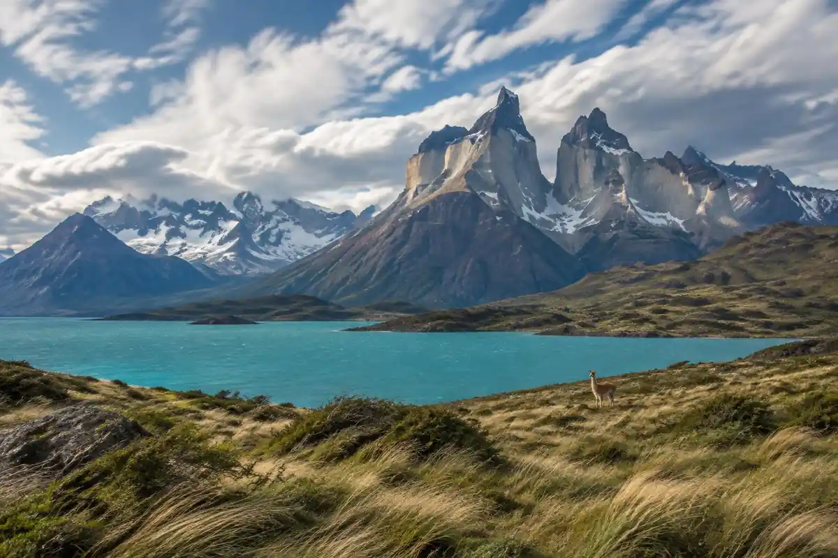 Granite towers over a turquoise lake with a windswept steppe foreground