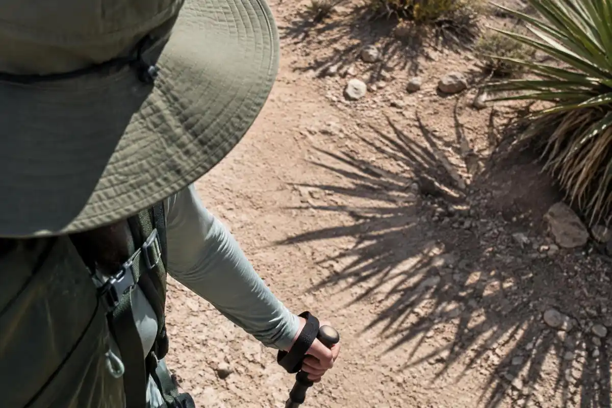 Sweat-stained hat brim and shaded sun-protective sleeve with a shadow of a cactus