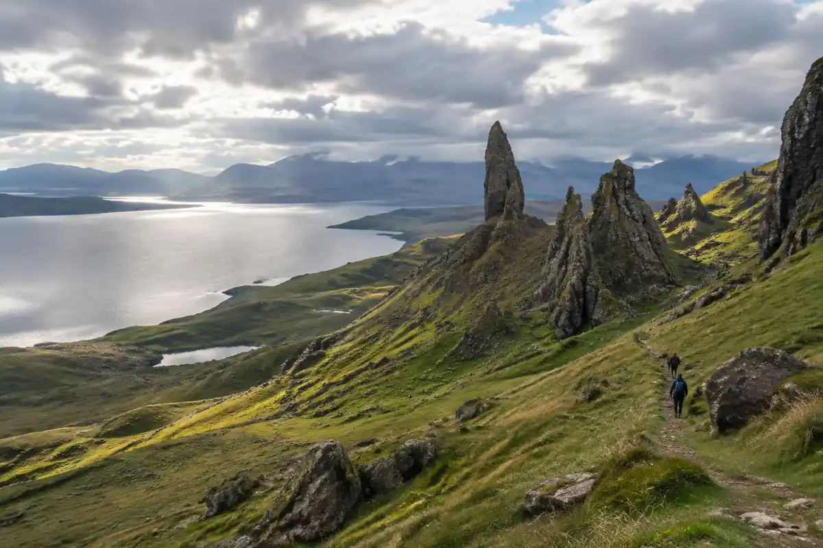 Rocky pinnacles above a green moorland slope with a sea loch beyond