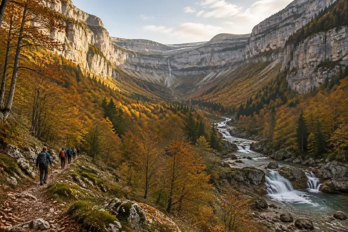 U-shaped limestone canyon with tiered cliffs, beech forest and cascades in autumn