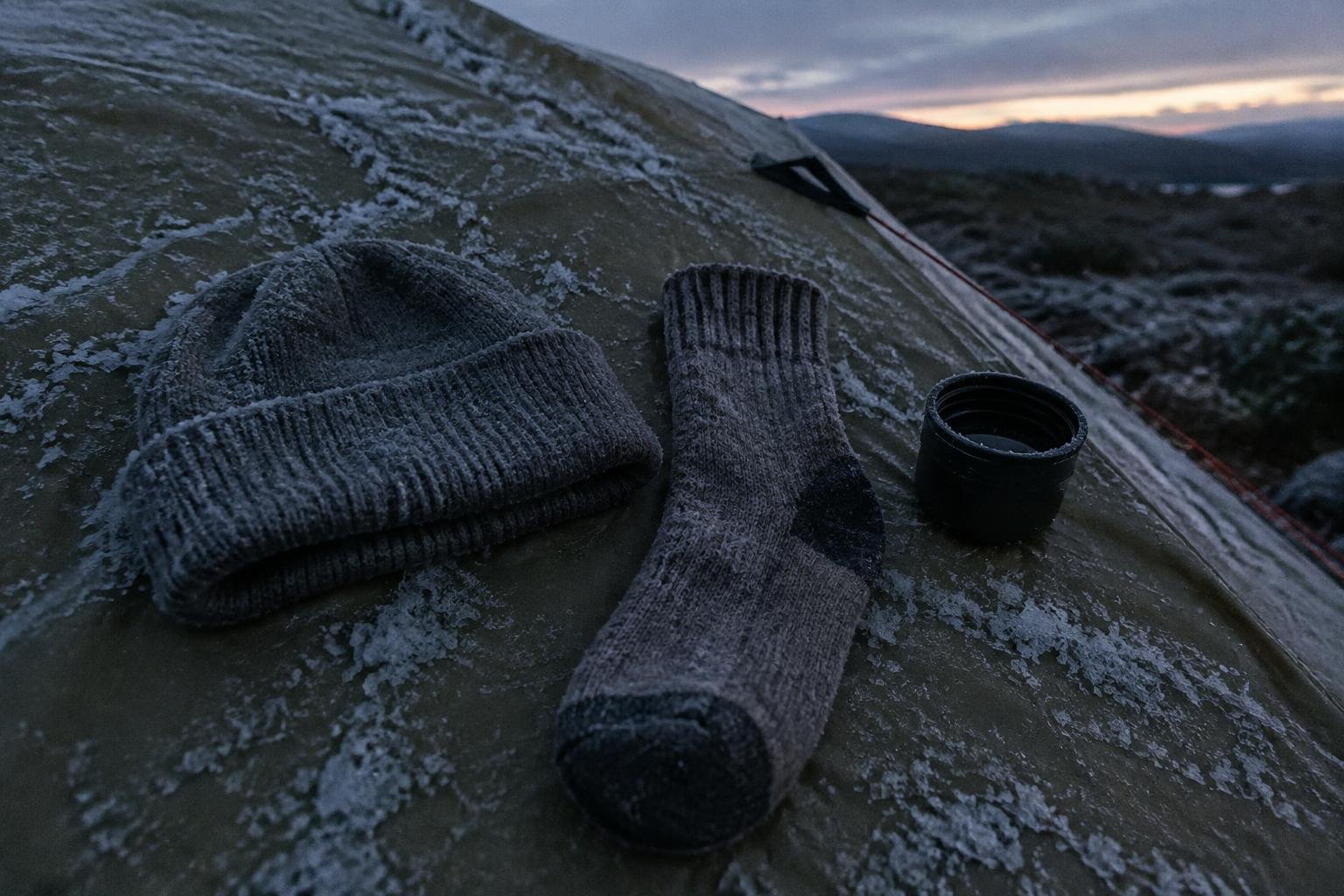 A beanie and a sock on a frosty tent flysheet