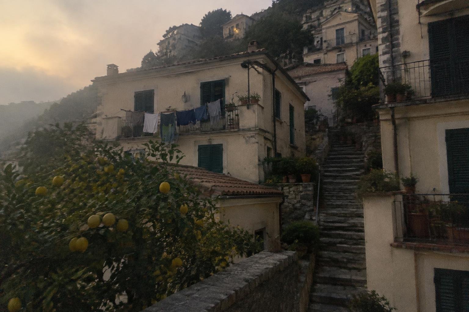 Lemon trees and a wall of old stone houses in a hill village